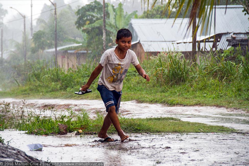 Un niño juega bajo la lluvia en Lagunas.